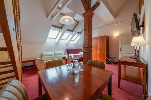 a dining room with a wooden table and chairs at Hotel Raffaello Prague in Prague