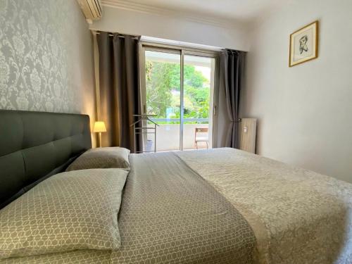 une chambre avec un grand lit et une fenêtre dans l'établissement Le Panomagique, à Villefranche-sur-Mer