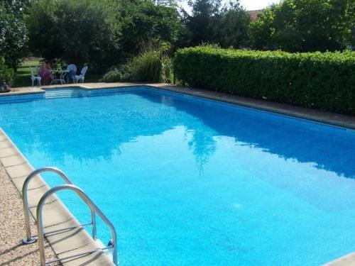 a large swimming pool with blue water in a yard at Idyllic Gite Holidays In Rural Stunning French Countryside With Pool in Antigny