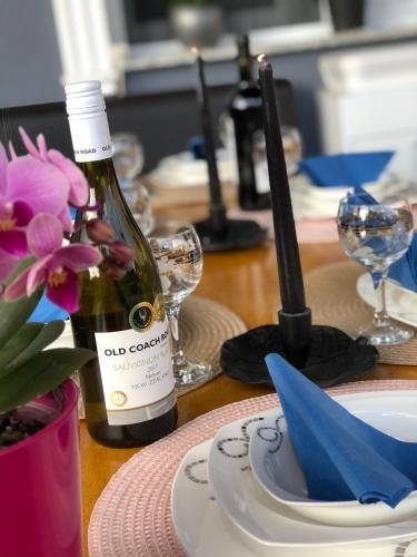a bottle of wine sitting on a table with a plate at Beautiful 4-Bed House in the Weinviertel in Hollabrunn
