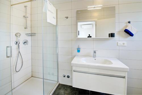 a bathroom with a sink and a shower at Cool Šilo Appartement Resort in Šilo