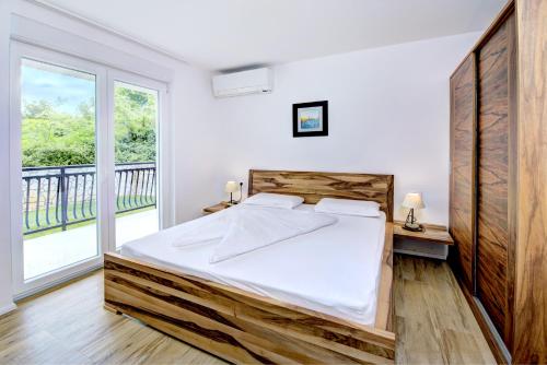 a bedroom with a bed and a large window at Cool Šilo Appartement Resort in Šilo