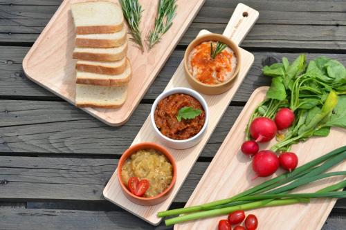 a table topped with two cutting boards with different foods at Tinutul Luanei Glamping Resort in Bozioru