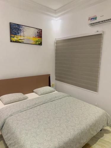 a bedroom with a bed and a window with a shutter at RESIDENCE MH SERVICES Cotonou in Cotonou