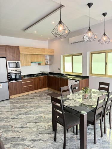 a kitchen with a table and chairs in a room at RESIDENCE MH SERVICES Cotonou in Cotonou
