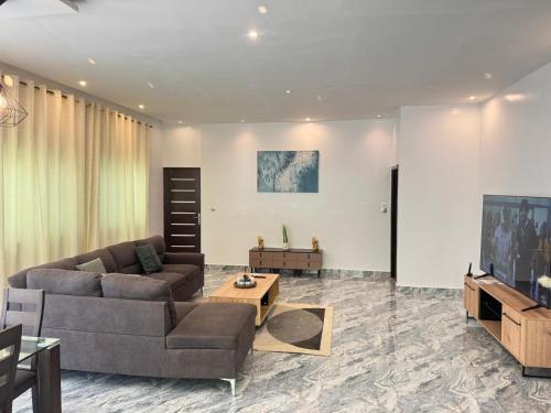 a living room with a couch and a tv at RESIDENCE MH SERVICES Cotonou in Cotonou
