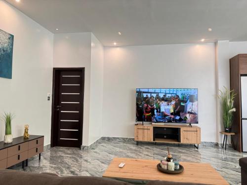a living room with a flat screen tv on a wall at RESIDENCE MH SERVICES Cotonou in Cotonou