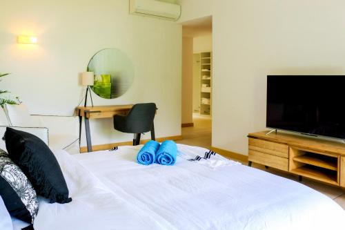 a bedroom with a bed with blue flip flops on it at Manta Cove by Horizon Holidays in Tamarin