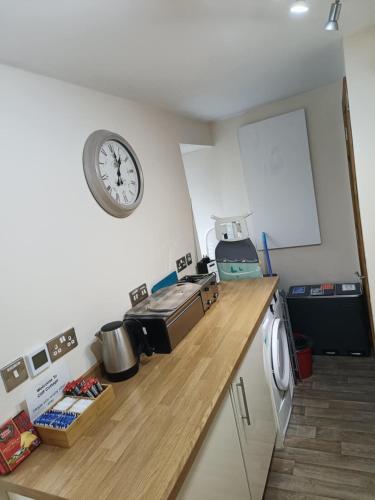 a kitchen with a counter with a clock on the wall at Cliff Cottage in Kyle of Lochalsh