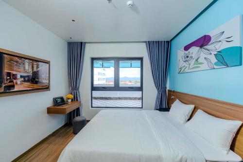 a bedroom with a large bed and a window at RosaLie Quảng Bình Hotel in Dong Hoi