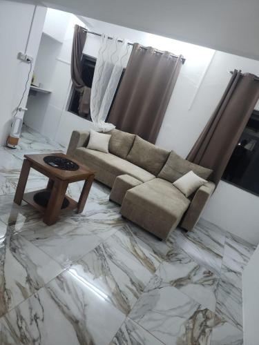 a living room with a couch and a table at Snz Guesthouse in Port Louis