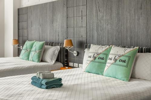 a bedroom with two beds with green and white pillows at 白水木民宿 in Eluan
