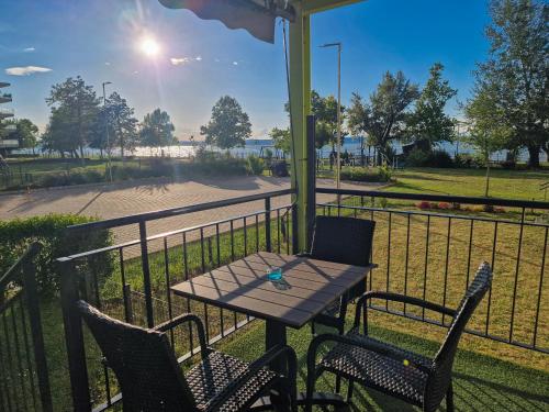 a table and chairs on a porch with a view of a park at Mystic7 Apartman in Siófok