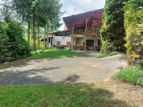 a house with a gambrel roof and a patio at Farma Zdrowia in Znamirowice