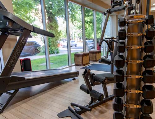 a gym with a bench and a tread machine at Lion's Garden Hotel in Budapest