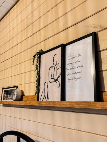 a shelf with two framed pictures on top of it at Willow Tiny House - ElysianFields in Sadu