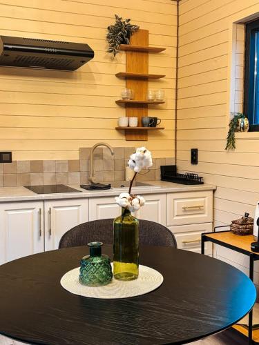 a vase with flowers on a table in a kitchen at Willow Tiny House - ElysianFields in Sadu