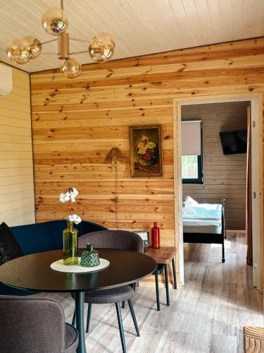 a room with a wooden wall with a table and chairs at Willow Tiny House - ElysianFields in Sadu