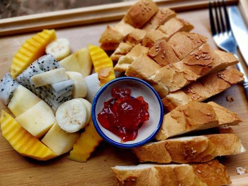 Un plato de pan y fruta y un tazón de ketchup en Discover Kratie Homesetay, en Kratié