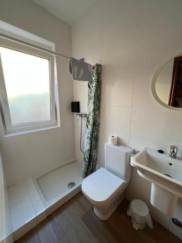 a white bathroom with a toilet and a sink at Pensión Plaza in Palas de Rei 