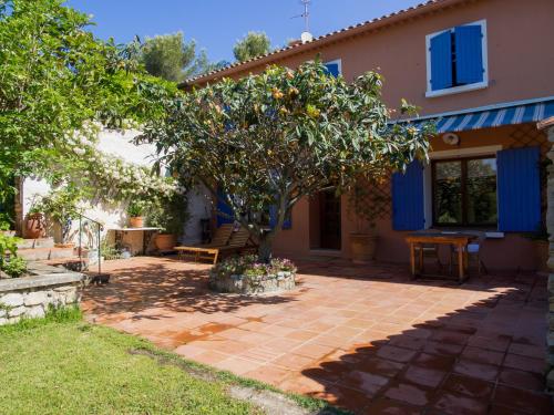 un patio avec un arbre devant une maison dans l'établissement Les Escouradières dans le Var, au Beausset