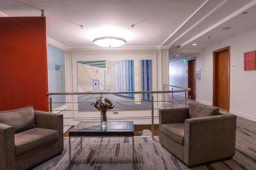a lobby with two chairs and a glass table at Lion's Garden Hotel in Budapest