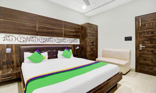 a bedroom with a large bed and a chair at Itsy Hotels Anjali Mahal, 500 Mtrs From Mathura Railway Station in Mathura