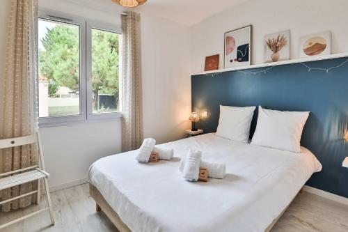 - une chambre avec un grand lit blanc et un mur bleu dans l'établissement Charmante maison proche mer, quartier paisible, à Olonne-sur-Mer