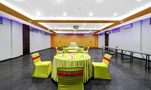a banquet hall with green tables and yellow chairs at Itsy Hotels Anjali Mahal, 500 Mtrs From Mathura Railway Station in Mathura