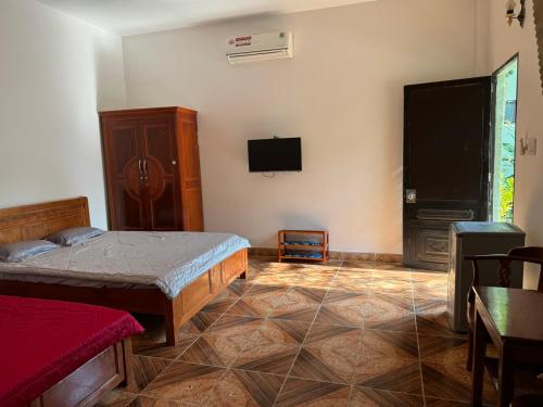 a bedroom with a bed and a flat screen tv at Hotel Thien Duong Xanh in Bình Chuẩn