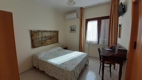 a small bedroom with a bed and a desk at B&B Le Ginestre in Foria