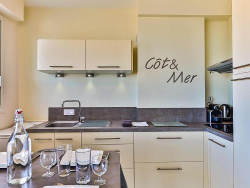 - une cuisine avec des verres à vin sur un comptoir dans l'établissement Studio cosy lumineux, front de mer, proche plage, à Les Sables-dʼOlonne