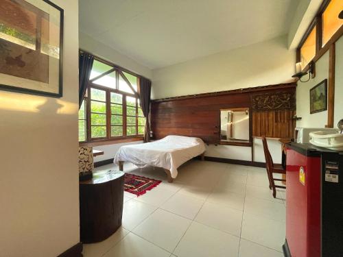 a bedroom with a bed and a window in it at Muangkham in Chiang Rai