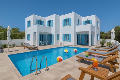 a villa with a swimming pool in front of a house at Ippocampos Seaside Serenity - Unwind at Paros Poolside Retreats in Aliki