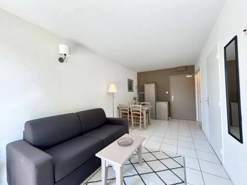 un salon avec un canapé et une table dans l'établissement T2 nature avec terrasse cosy, à Bénodet