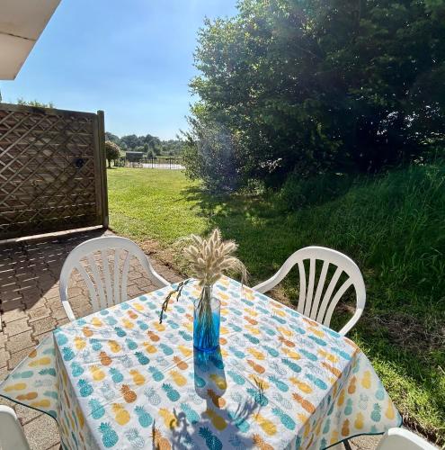 une table avec un vase de fleurs au-dessus dans l'établissement T2 nature avec terrasse cosy, à Bénodet