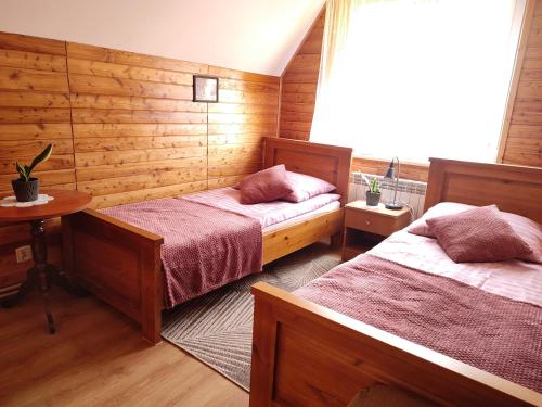 a bedroom with two beds and a window at Agroturystyka Wypoczynek nad Bugiem in Klepaczew