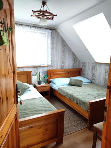 a bedroom with two beds and a window at Agroturystyka Wypoczynek nad Bugiem in Klepaczew