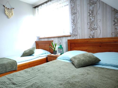 a bedroom with two beds and a window at Agroturystyka Wypoczynek nad Bugiem in Klepaczew