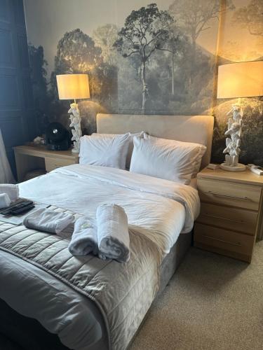 a bedroom with a large bed with towels on it at The Q Hotel in Shanklin