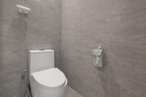 a bathroom with a toilet and a tiled wall at 白水木民宿 in Eluan