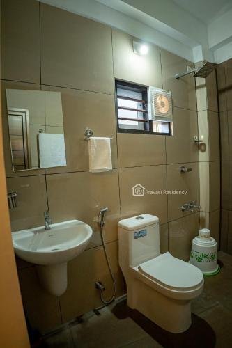 a bathroom with a toilet and a sink at Elite Residency in Vāniyambalam