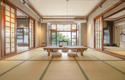 a large room with a wooden table and windows at Xueershanfang · Shanhaijing in Sanya