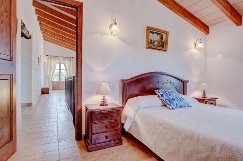 a bedroom with a bed and a dresser and a mirror at Son Burguet in Llubí