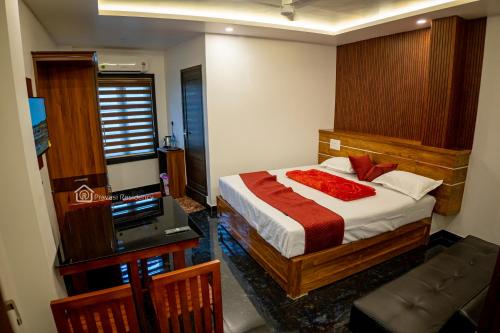 a bedroom with a bed and a flat screen tv at Elite Residency in Vāniyambalam