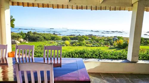 a table and chairs on a porch with a view of the ocean at Amore in West Point