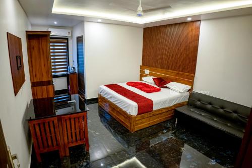 a bedroom with a bed with red pillows on it at Elite Residency in Vāniyambalam