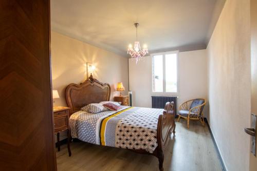 une chambre avec un lit et un lustre dans l'établissement Chez georgette, à Sarlat-la-Canéda