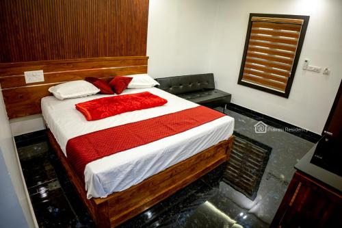 a bedroom with a bed with white and red sheets at Elite Residency in Vāniyambalam