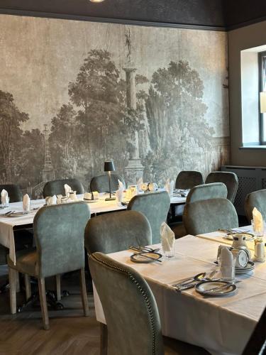 a dining room with tables and chairs and a wall mural at The Q Hotel in Shanklin